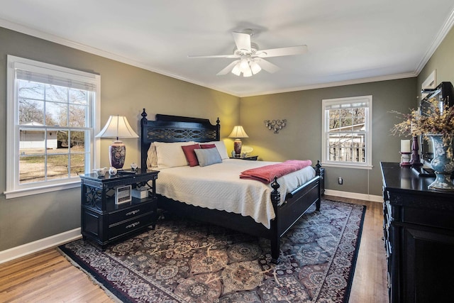 bedroom with a ceiling fan, crown molding, baseboards, and wood finished floors