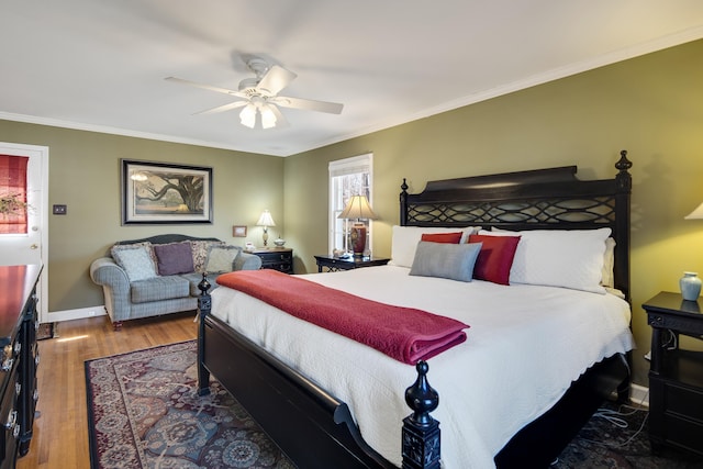 bedroom with crown molding, wood finished floors, baseboards, and ceiling fan