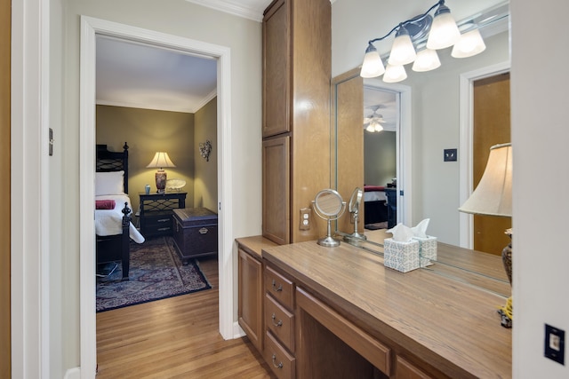 ensuite bathroom with ceiling fan with notable chandelier, ensuite bath, wood finished floors, and ornamental molding