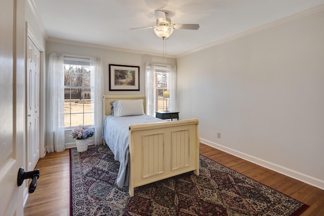 bedroom with ceiling fan, wood finished floors, baseboards, and ornamental molding