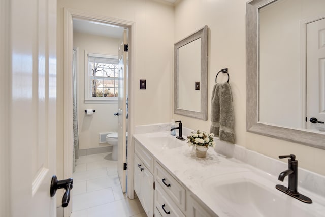 full bath featuring double vanity, toilet, tile patterned floors, and a sink