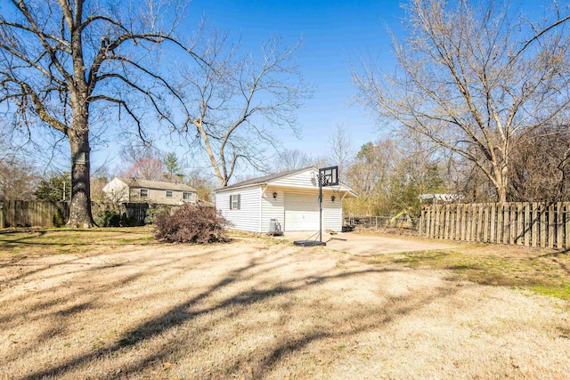 view of yard featuring a garage, an outdoor structure, and fence