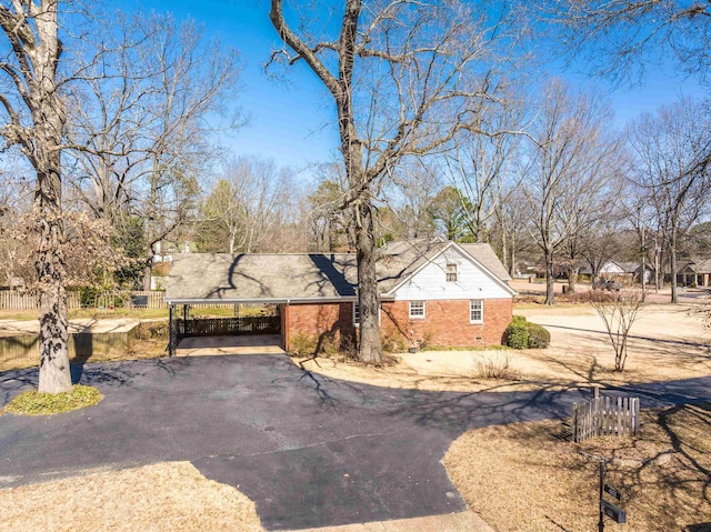 view of front facade with fence, brick siding, and driveway