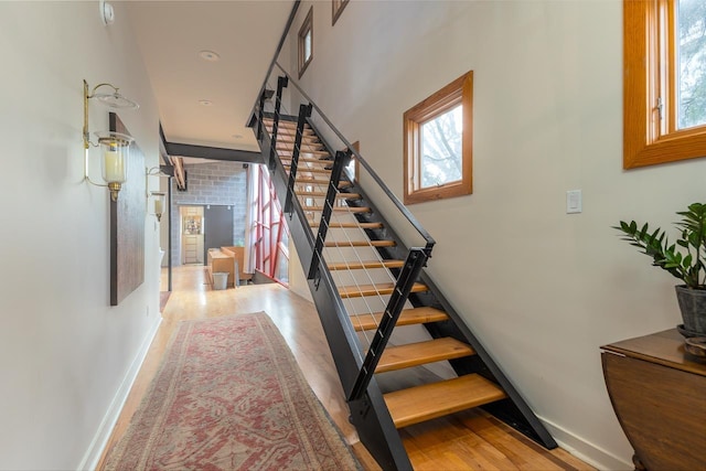 stairway featuring wood finished floors and baseboards