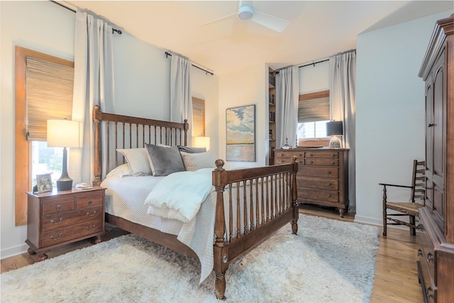 bedroom featuring a ceiling fan, baseboards, and wood finished floors