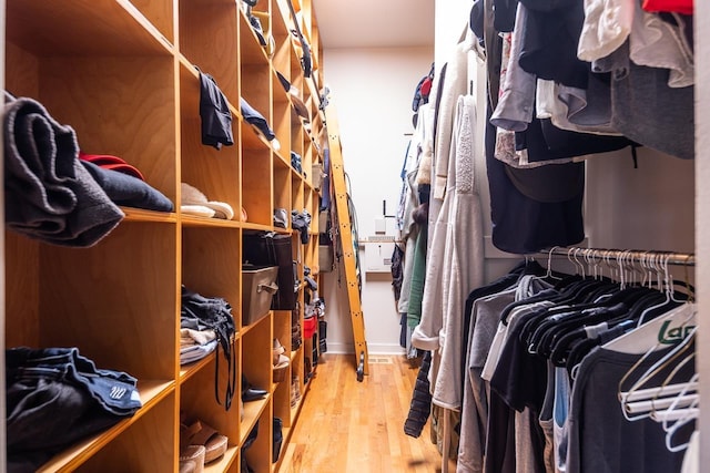 walk in closet with wood finished floors