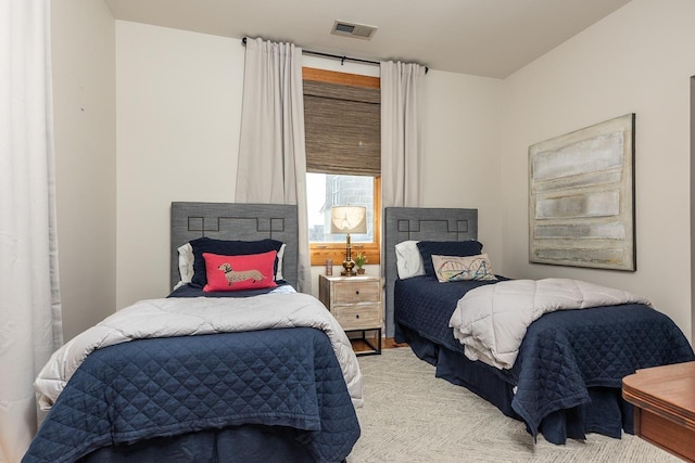 bedroom featuring visible vents and light colored carpet