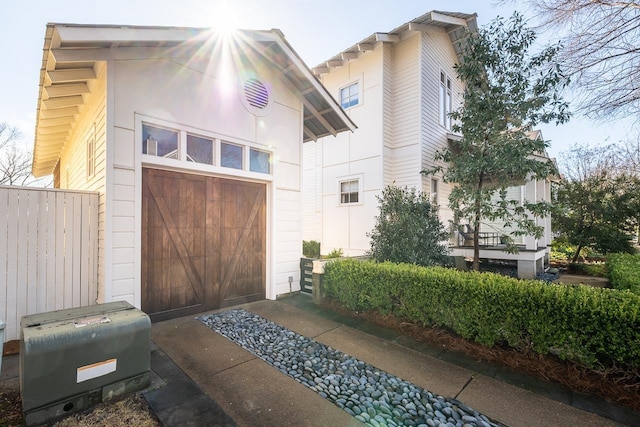 garage with a storage unit and fence