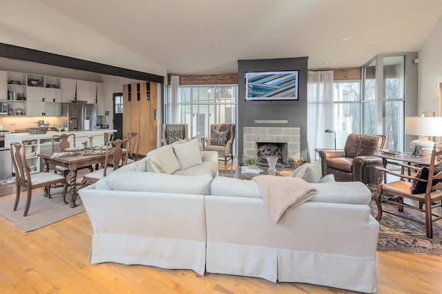 living room with recessed lighting, a large fireplace, and light wood-style floors