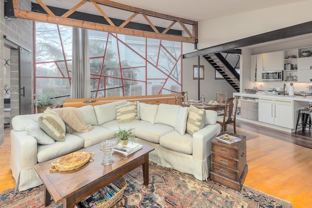 living room with light wood-style flooring and stairs