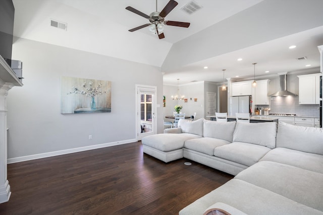 living area with dark wood-style floors, visible vents, ceiling fan with notable chandelier, and baseboards