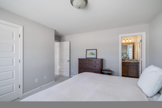 bedroom with ensuite bath, carpet, and baseboards