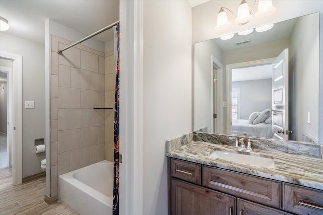 ensuite bathroom featuring visible vents, toilet, wood finished floors, connected bathroom, and vanity