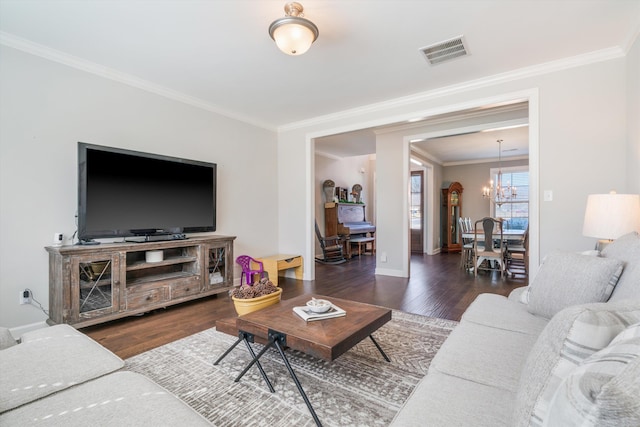 living room featuring visible vents, crown molding, baseboards, an inviting chandelier, and wood finished floors