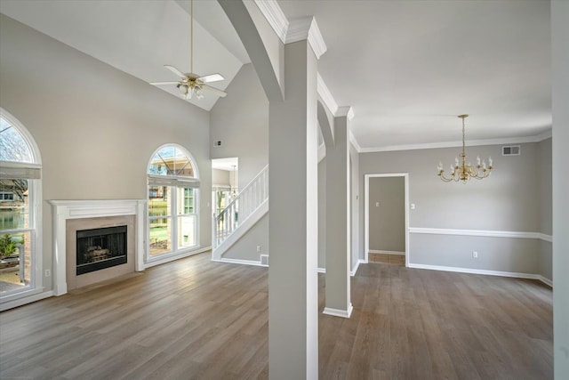 unfurnished living room featuring plenty of natural light, wood finished floors, baseboards, and a high end fireplace