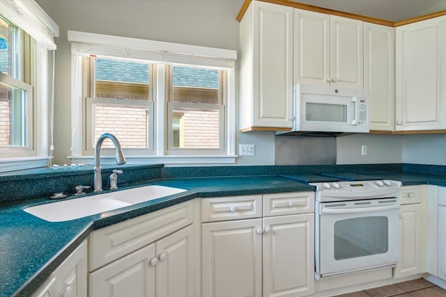 kitchen featuring a sink, white appliances, and white cabinets