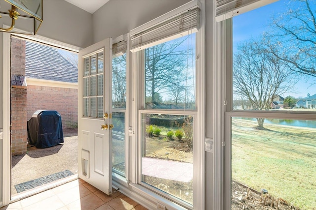 doorway to outside with tile patterned flooring and plenty of natural light