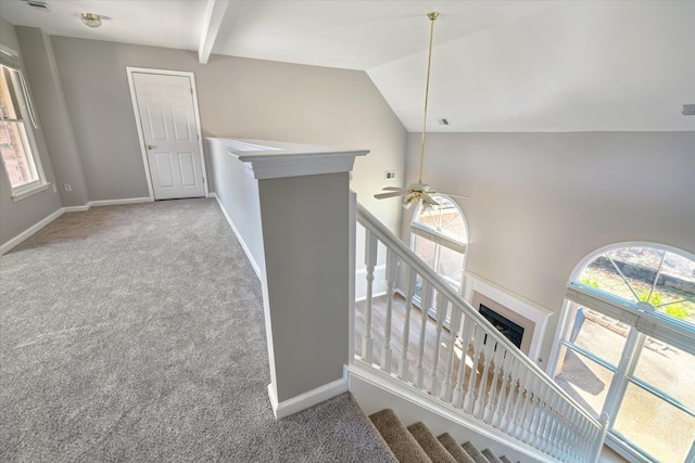 corridor with baseboards, carpet, and vaulted ceiling with beams