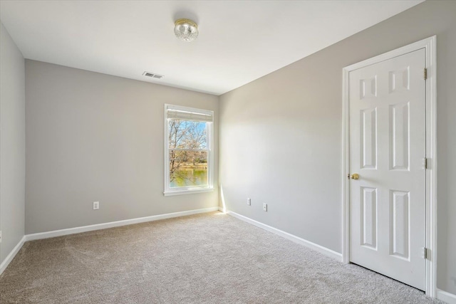 spare room featuring visible vents, baseboards, and carpet