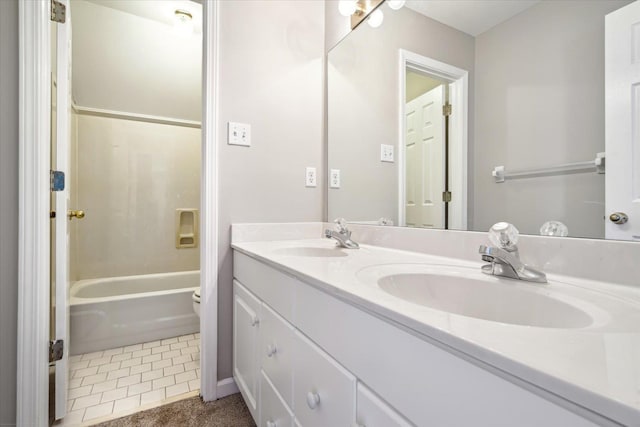 bathroom with a sink, toilet, double vanity, and tile patterned floors