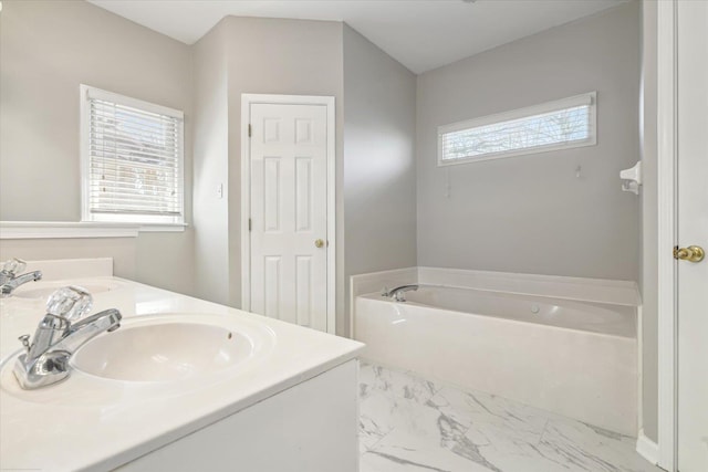 full bathroom with double vanity, a bath, marble finish floor, and a sink