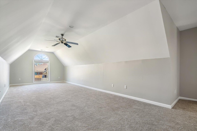 additional living space featuring carpet flooring, baseboards, ceiling fan, and vaulted ceiling