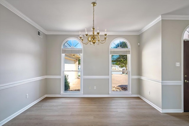 unfurnished dining area with an inviting chandelier, wood finished floors, and crown molding