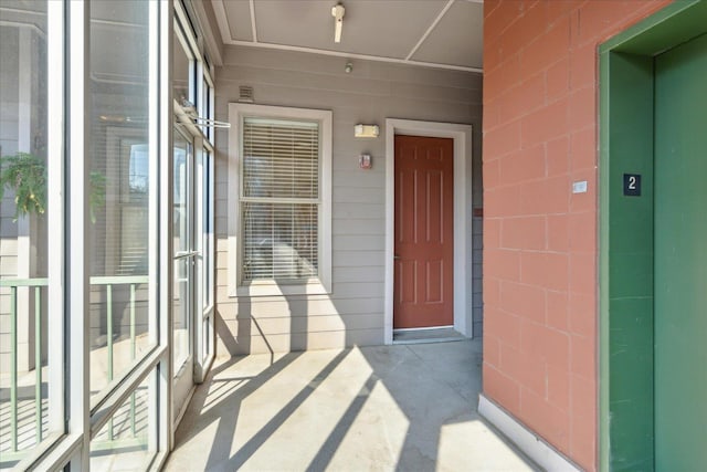 doorway to property featuring elevator and concrete block siding