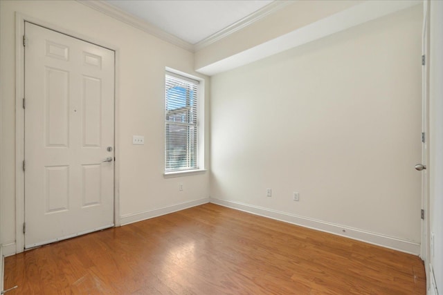 foyer entrance featuring light wood-type flooring, baseboards, and ornamental molding