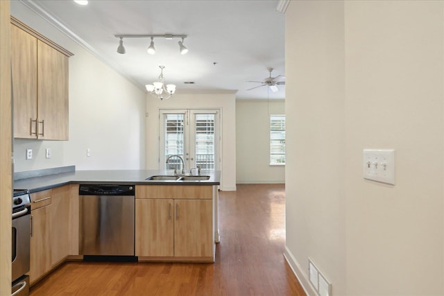 kitchen featuring visible vents, a peninsula, a sink, dishwasher, and range