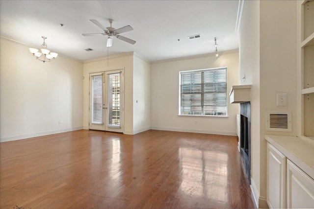 unfurnished living room featuring visible vents, light wood-style flooring, ornamental molding, ceiling fan with notable chandelier, and a fireplace