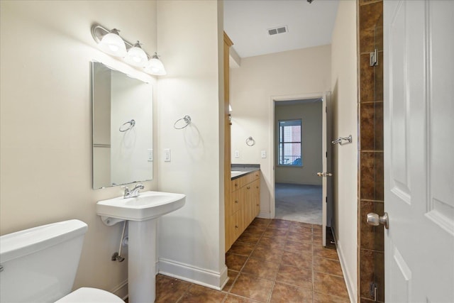 bathroom featuring tile patterned floors, visible vents, toilet, a sink, and baseboards