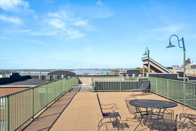 view of patio with a city view, a balcony, and a water view