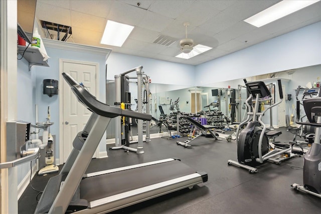 gym with visible vents, a paneled ceiling, and a ceiling fan