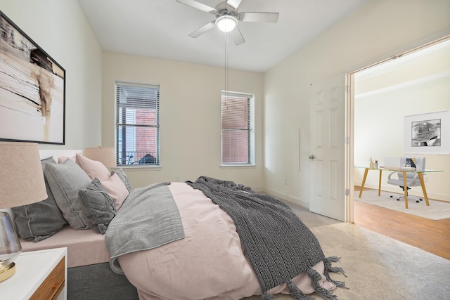 bedroom featuring baseboards, light colored carpet, and ceiling fan