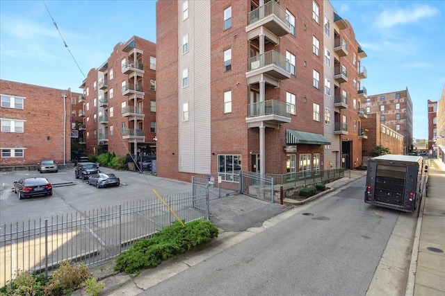 view of property featuring fence and uncovered parking