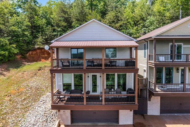 view of front facade with a balcony, metal roof, and a garage