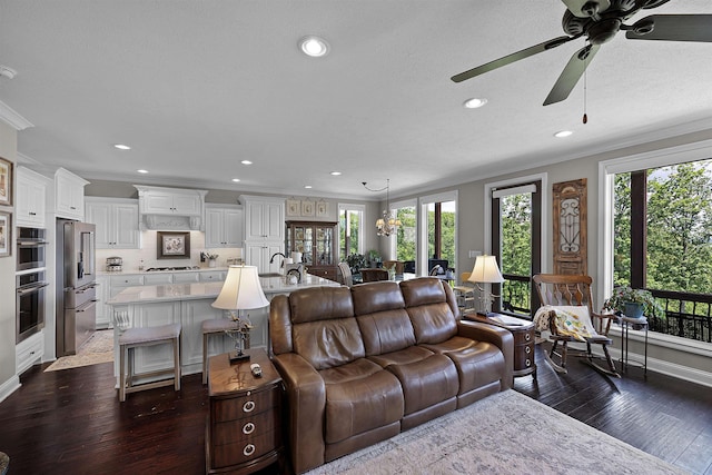 living area with crown molding, ceiling fan, dark wood-type flooring, recessed lighting, and a textured ceiling