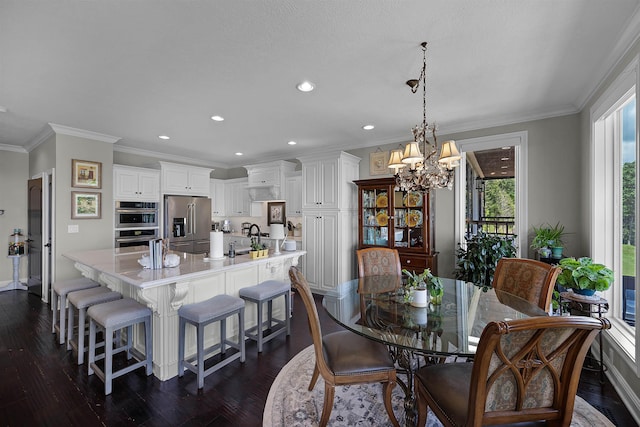 dining area with ornamental molding, recessed lighting, dark wood-style flooring, and a chandelier