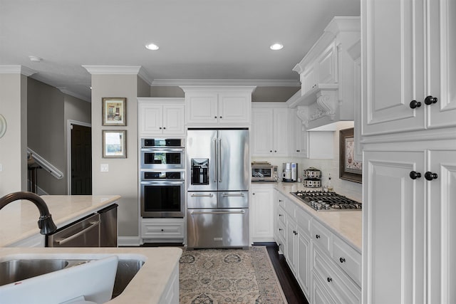 kitchen featuring a sink, light countertops, white cabinets, appliances with stainless steel finishes, and backsplash