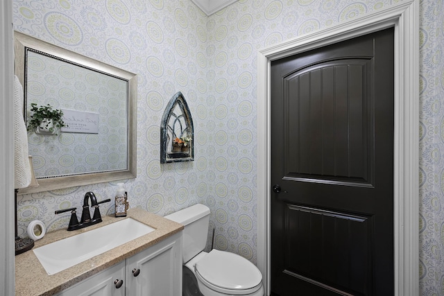 bathroom featuring wallpapered walls, toilet, and vanity