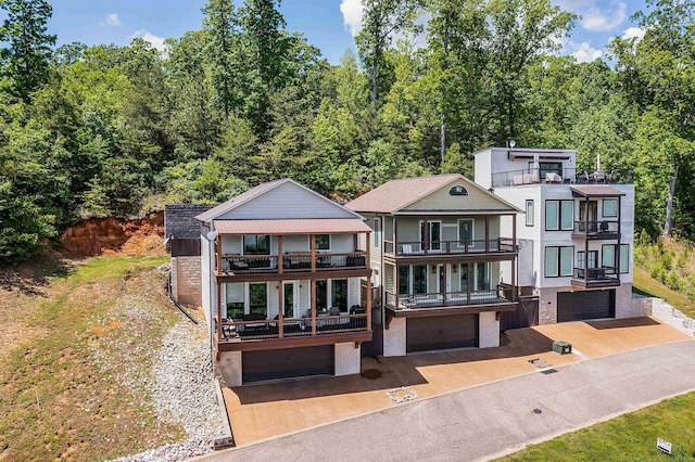 view of front facade featuring a balcony, driveway, and a garage