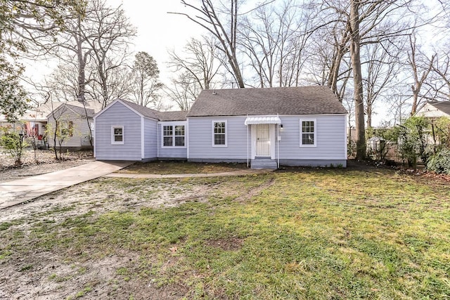 view of front of house featuring a front lawn and roof with shingles