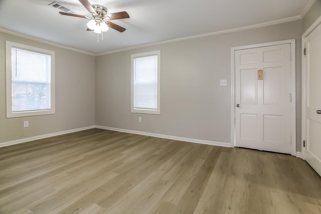 unfurnished room featuring a wealth of natural light, visible vents, a ceiling fan, and ornamental molding