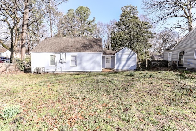 rear view of property featuring a yard, entry steps, and fence