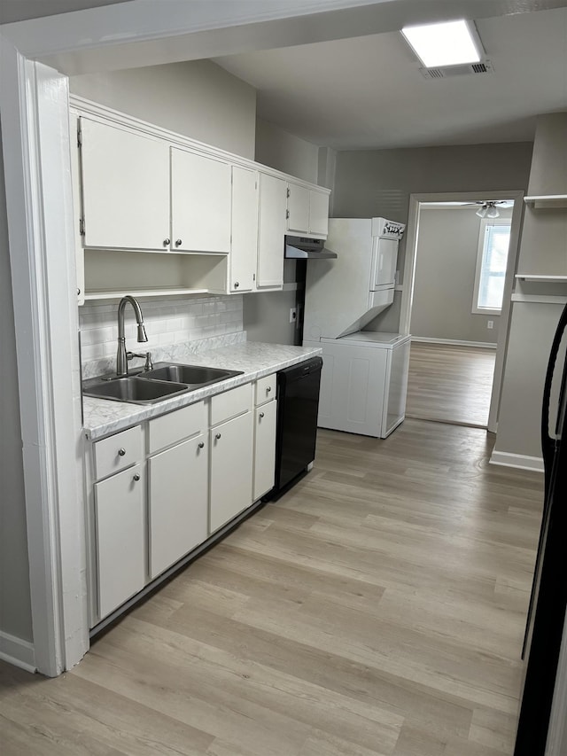 kitchen featuring a sink, black dishwasher, white cabinets, and light wood finished floors