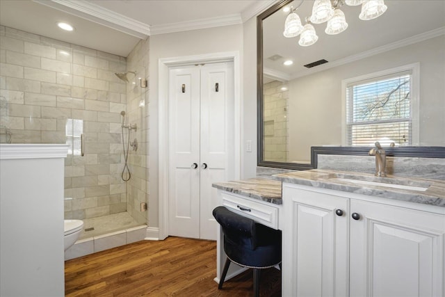 full bath featuring a stall shower, vanity, wood finished floors, and crown molding