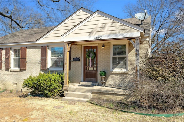 bungalow-style home featuring crawl space, brick siding, and a shingled roof