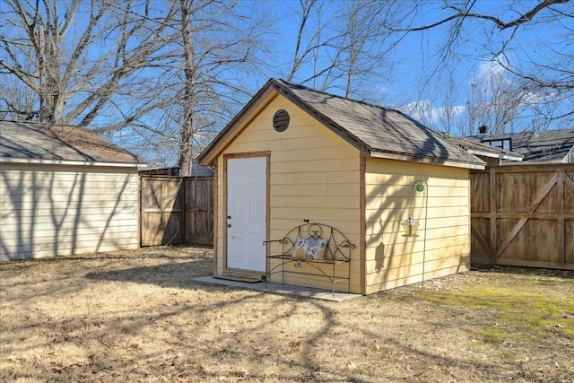 view of shed featuring a gate and fence