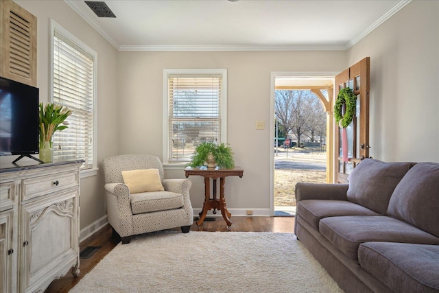 living area with visible vents, dark wood-type flooring, baseboards, and ornamental molding